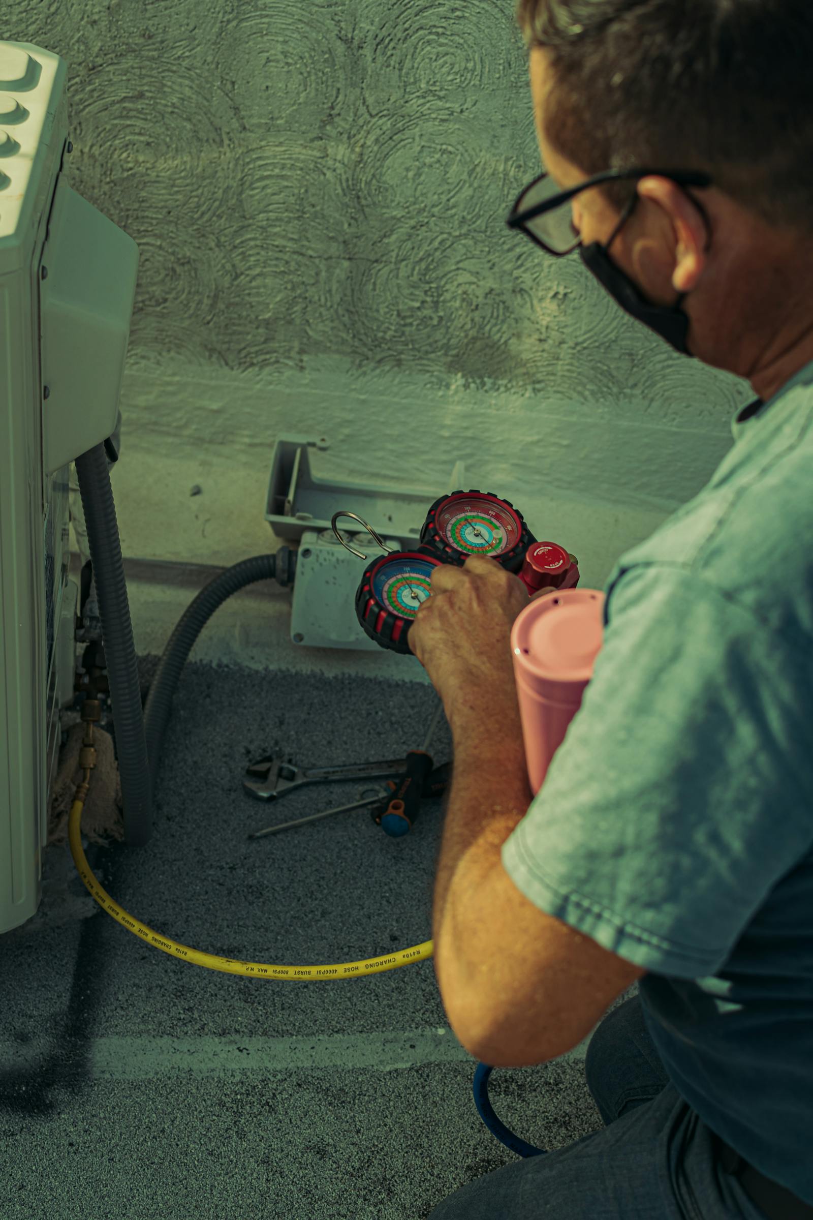 Technician checking air conditioning gauges during setup